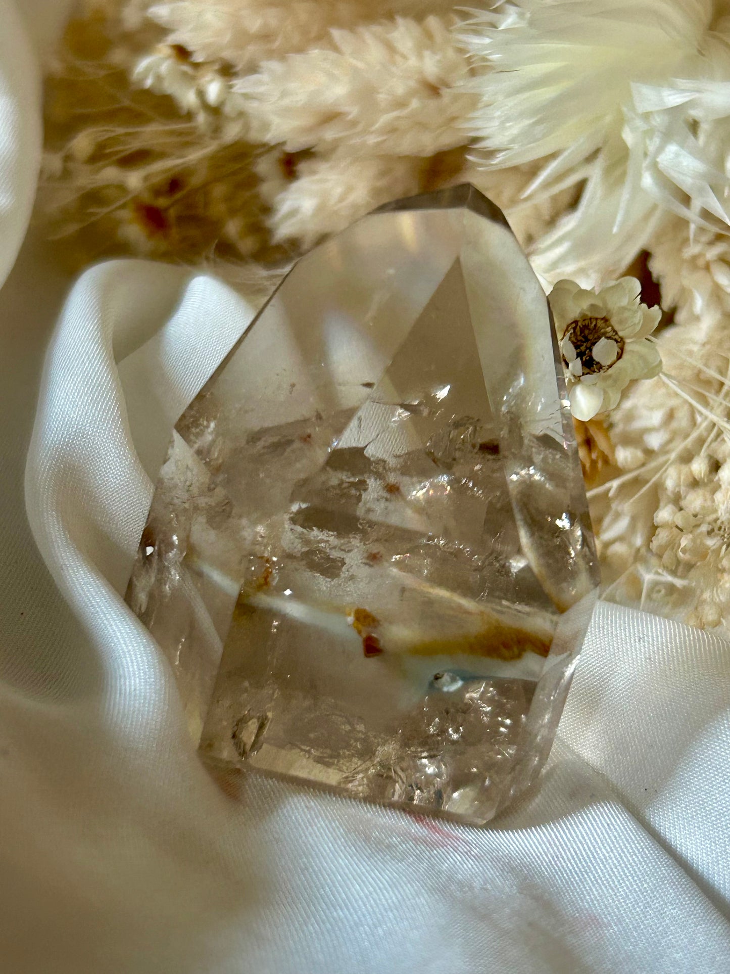 Amphibole Quartz crystal with soft cloud-like inclusions and gentle light play, standing upright on a neutral background