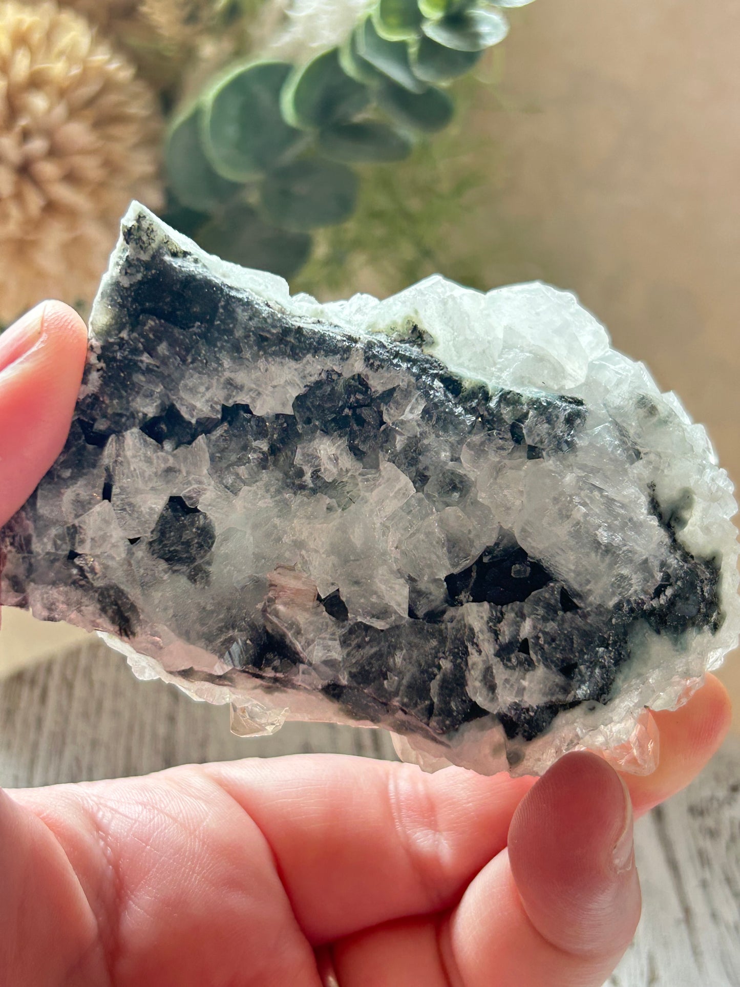 Hand holding a crystal with a blurred background