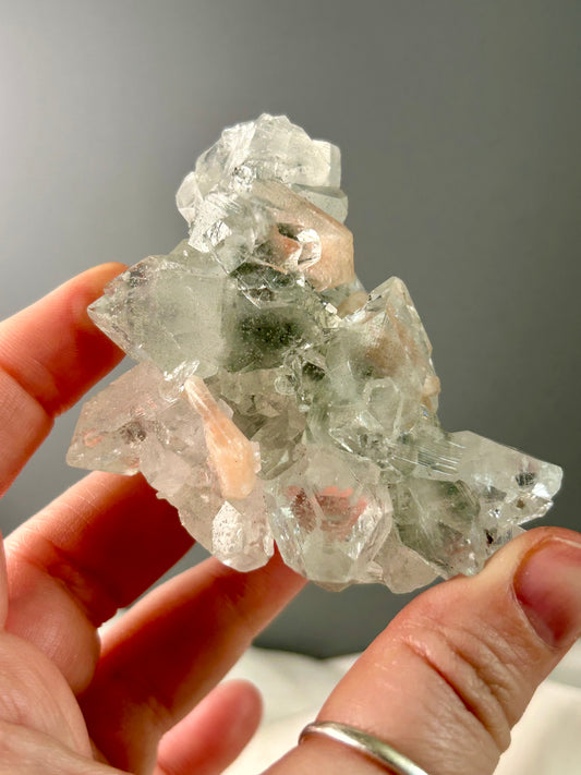 Clear apophyllite stalactite cluster on display, sparkling crystal formation.