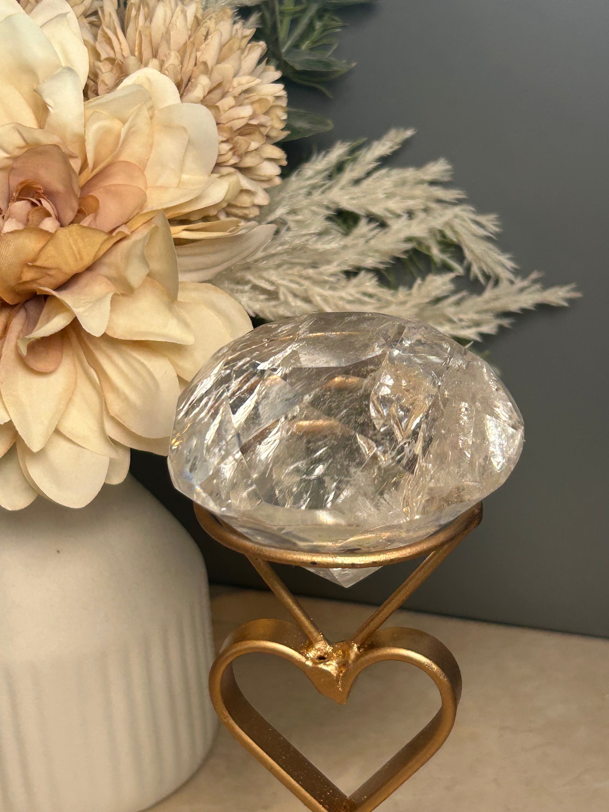 Faceted clear quartz crystal display piece on gold stand with geometric cut natural quartz specimen.