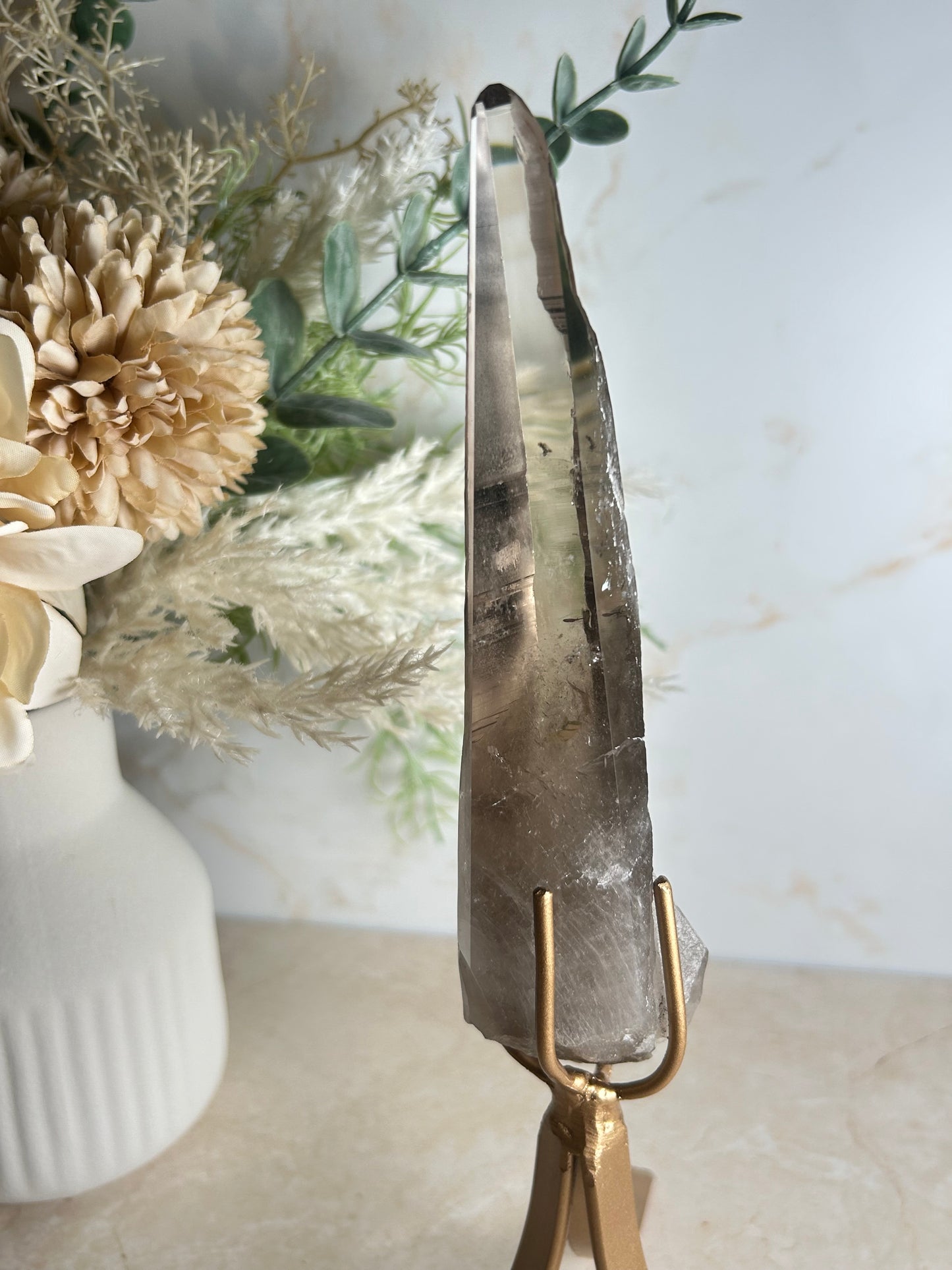 semi polished smoky quartz crystal point on gold display stand natural smoky quartz specimen
