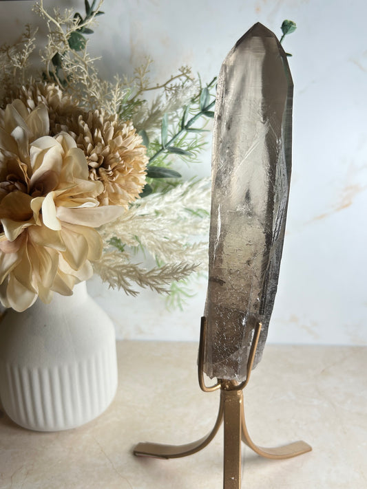 semi polished smoky quartz crystal point on gold display stand natural smoky quartz specimen