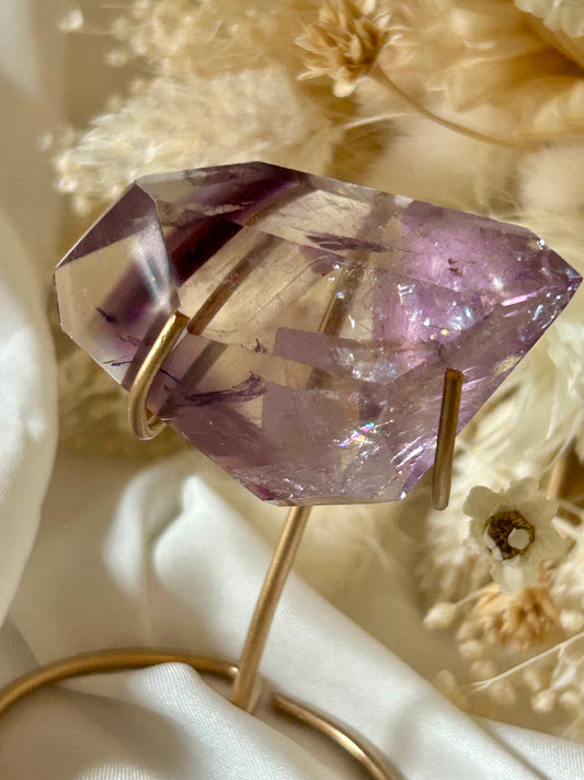 Gem-quality Phantom Amethyst freeform with visible internal layering and rich violet tones, standing upright on a soft background