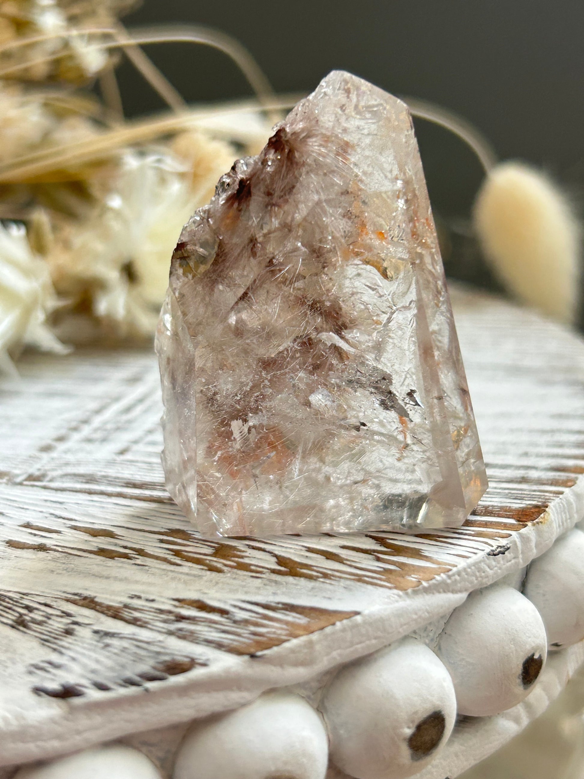 Polished lodolite rutile quartz point displaying natural inclusions formed within clear quartz.
