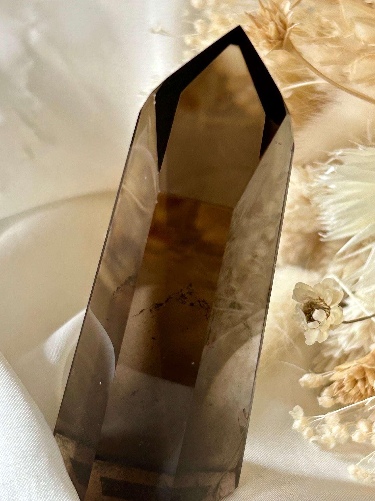 Smokey Quartz crystal with warm brown tones and soft clarity, standing upright on neutral background