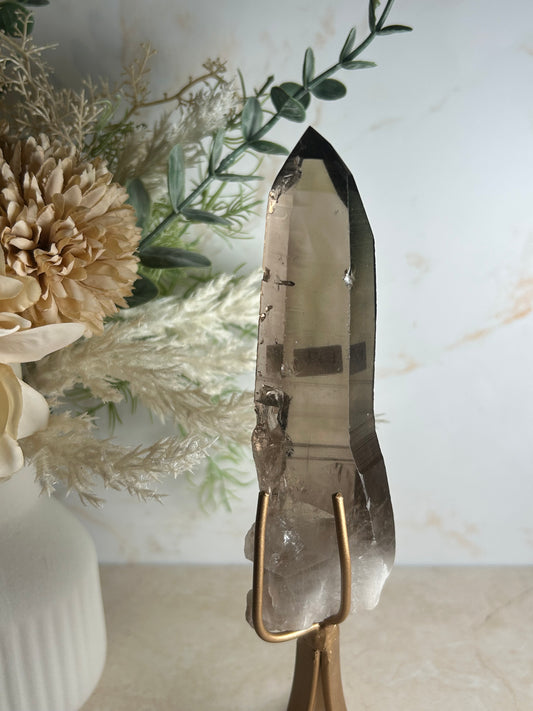 semi polished smoky quartz crystal point on gold display stand natural smoky quartz specimen