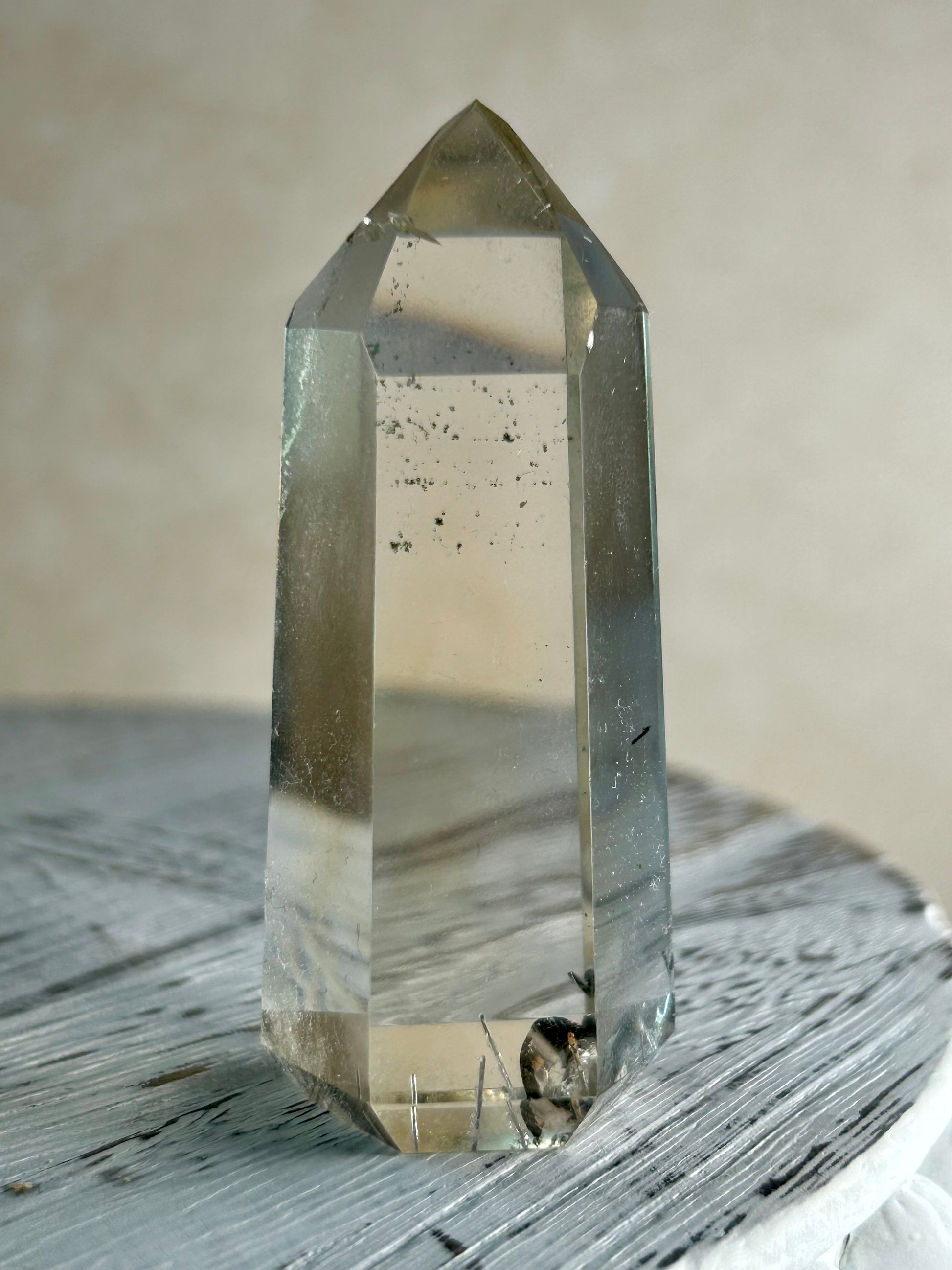 Citrine Rutile tower with golden threads on cream background and rustic wood surface