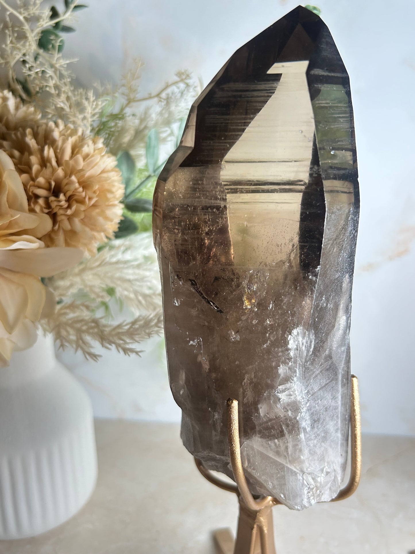 semi polished smoky quartz crystal point on gold display stand natural smoky quartz specimen