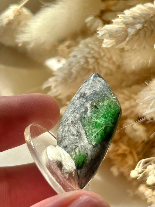 Polished green Smaragdite cabochon from France with visible actinolite inclusions – jewellery safe stone