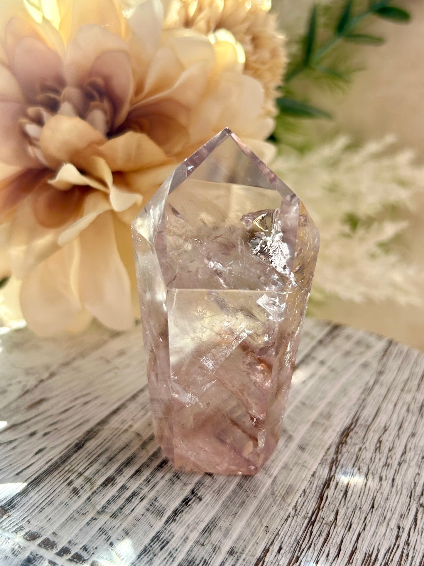 Crystal on a marble surface with flowers in the background