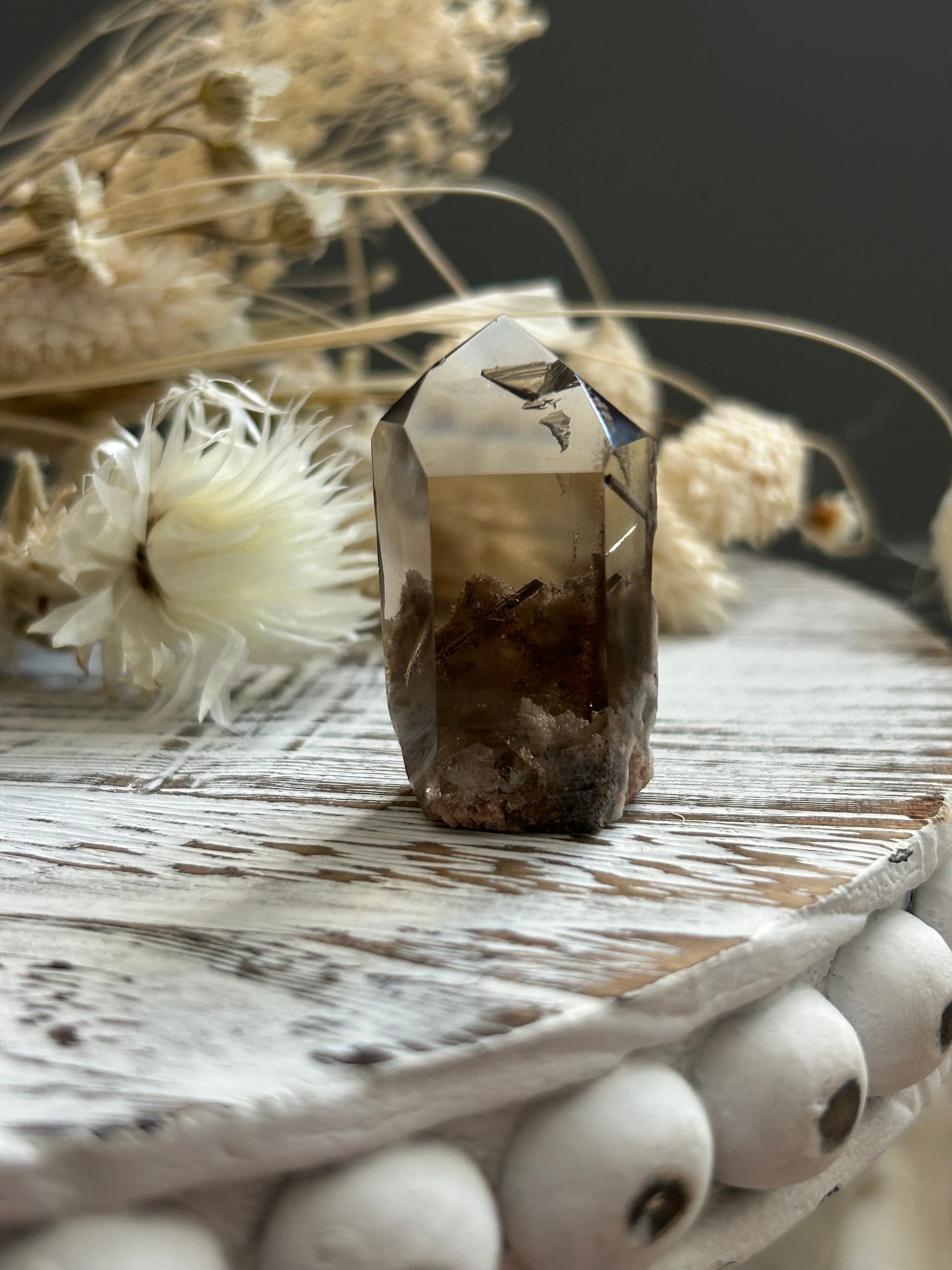High grade lodolite rutile quartz crystal with layered internal inclusions, photographed in soft natural light.