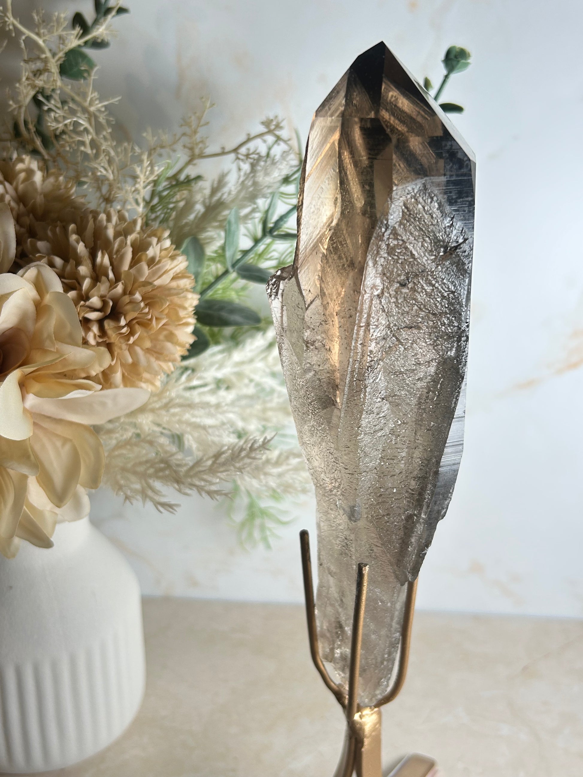semi polished smoky quartz crystal point on gold display stand natural smoky quartz specimen