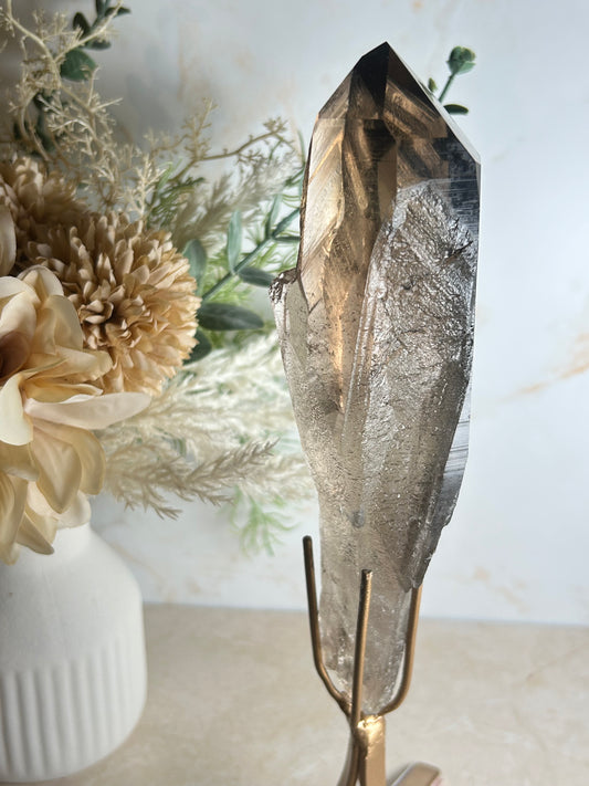 semi polished smoky quartz crystal point on gold display stand natural smoky quartz specimen