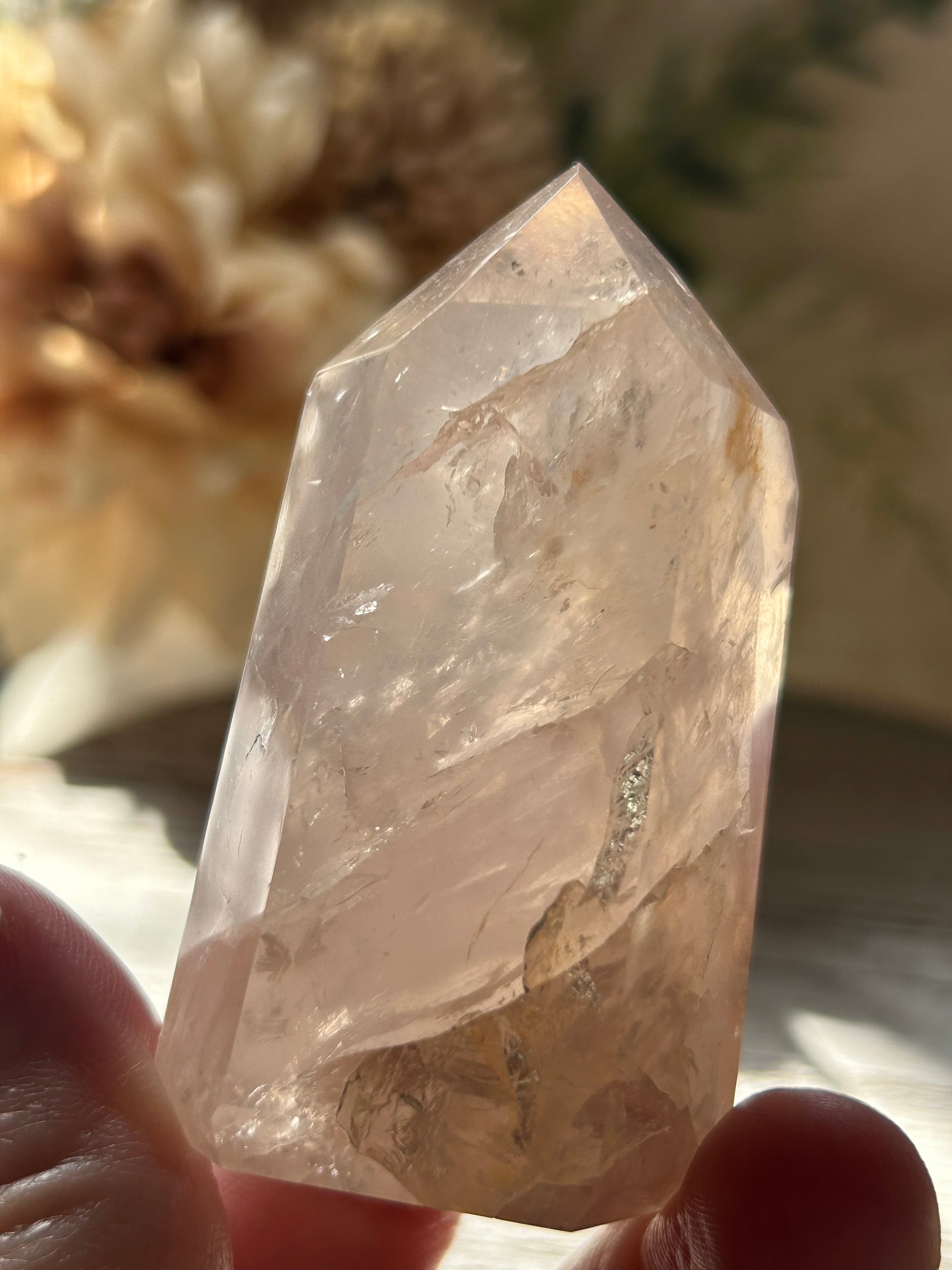 Crystal held by a hand with a blurred natural background