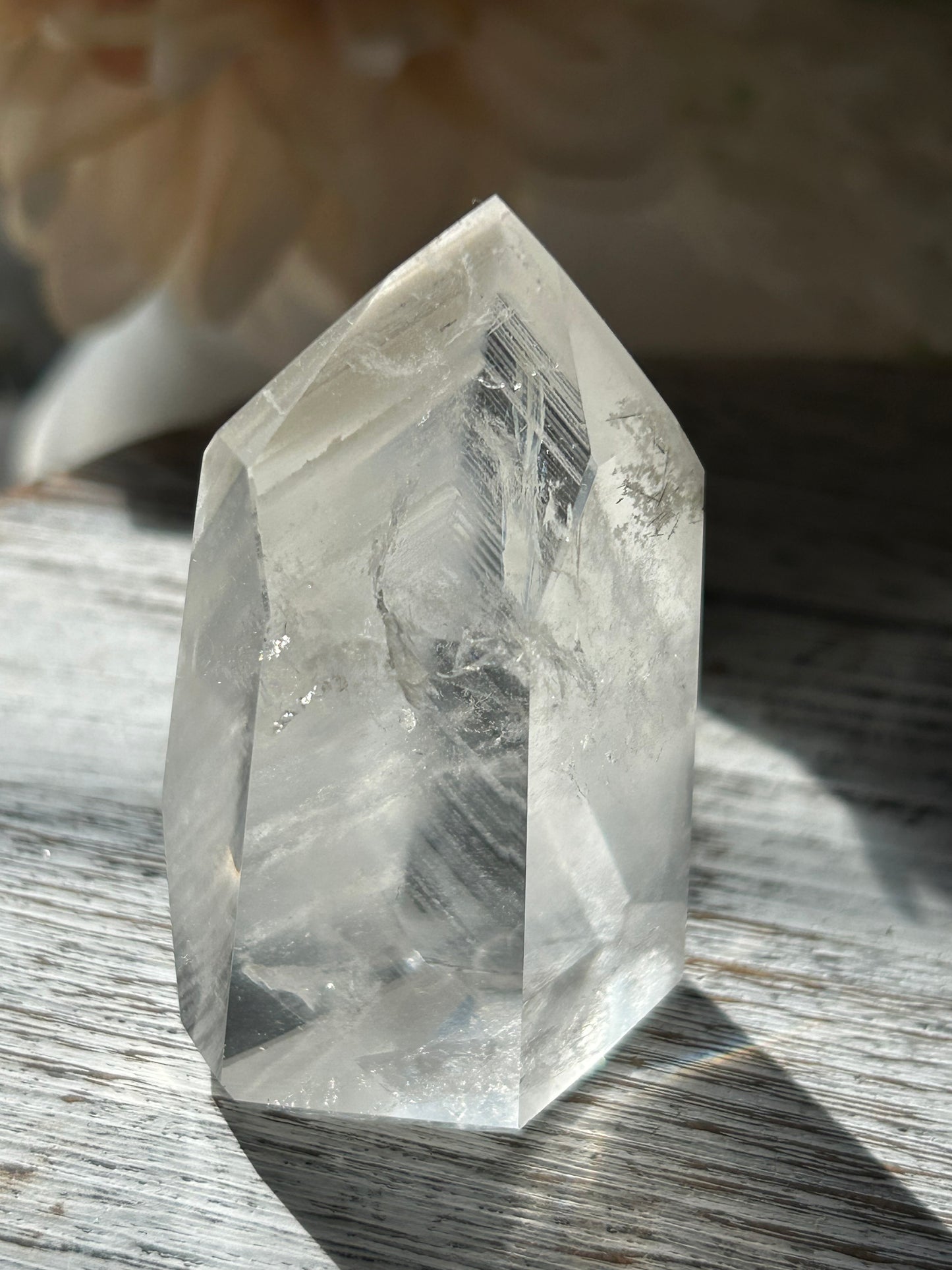 Polished Phantom Quartz tower with layered ghost-like inclusions and natural internal formations