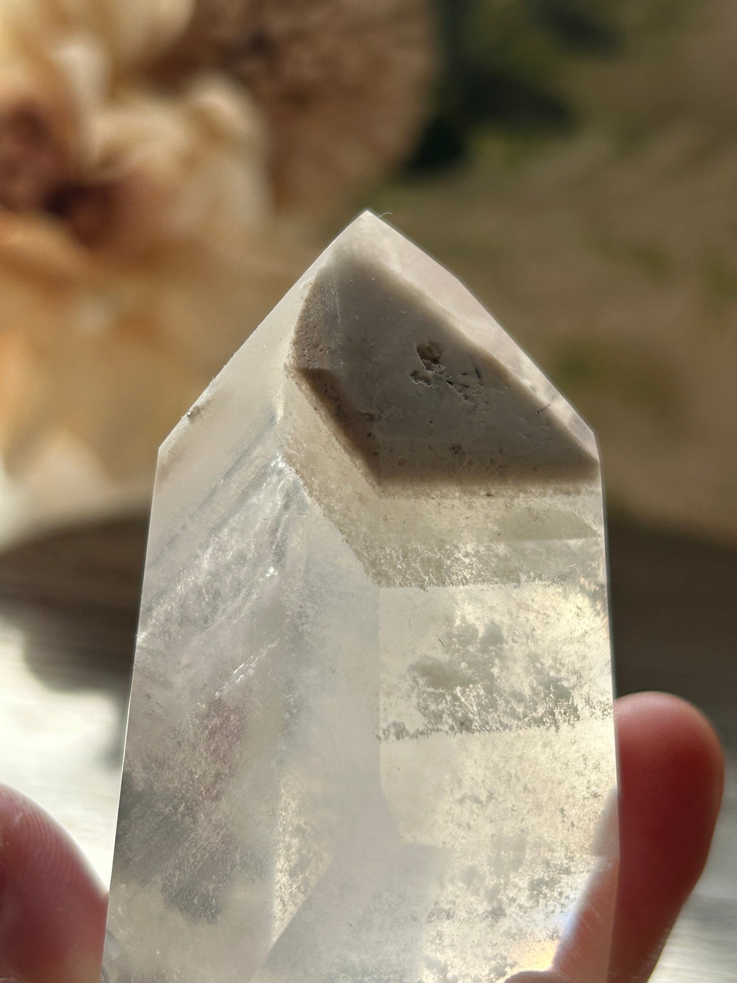 Crystal held by a hand with a blurred background