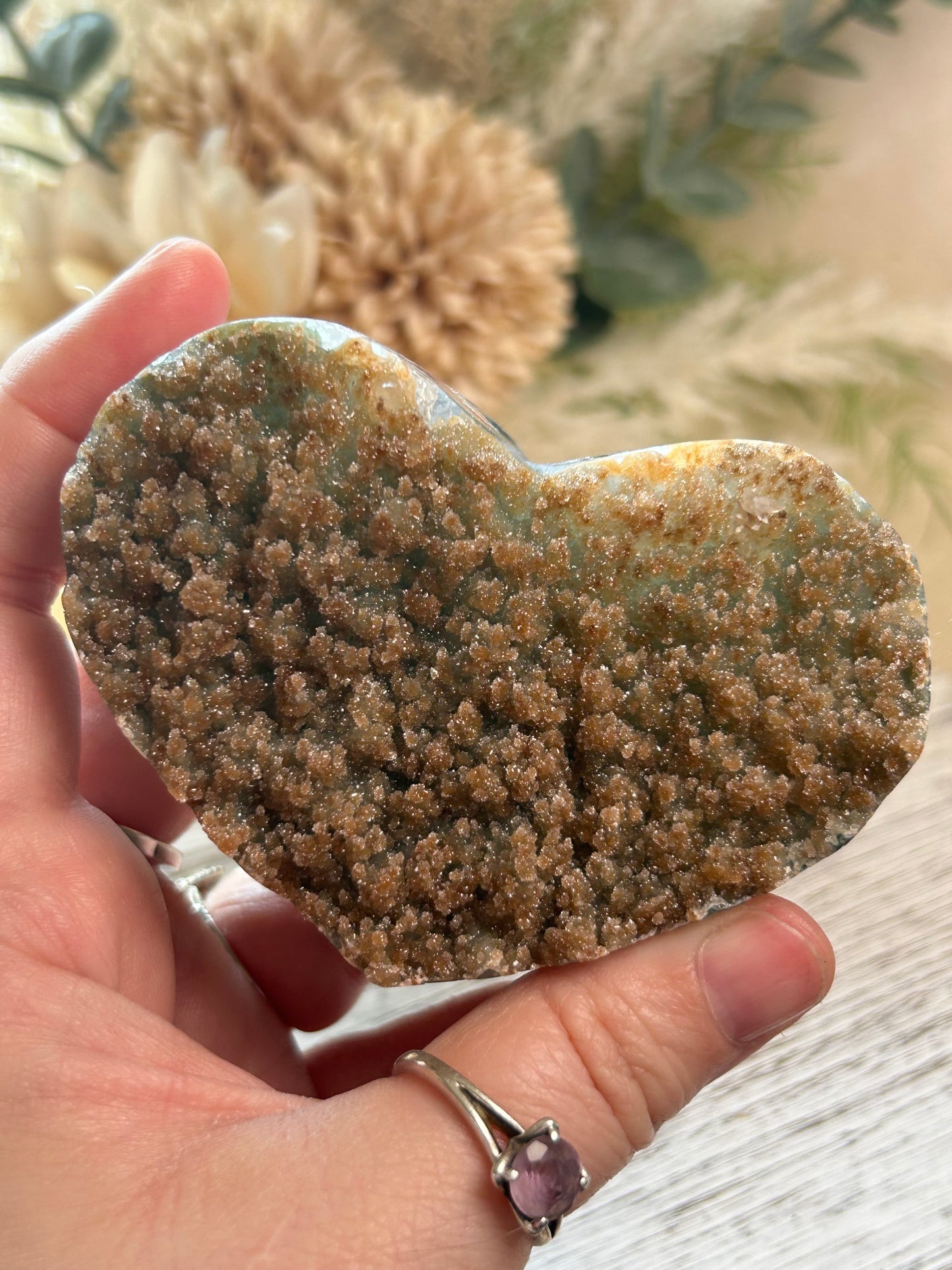 Mustard sugar druzy Rainbow Amethyst heart with sparkling golden crystal texture being held by hand.
