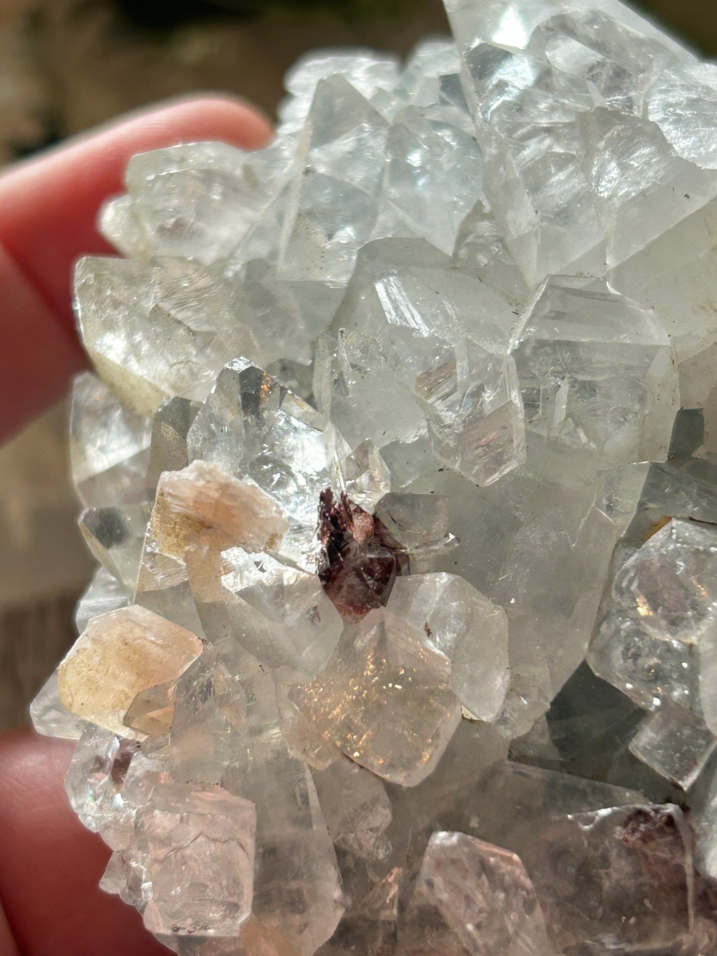 Close-up of clear crystal formations held by a hand