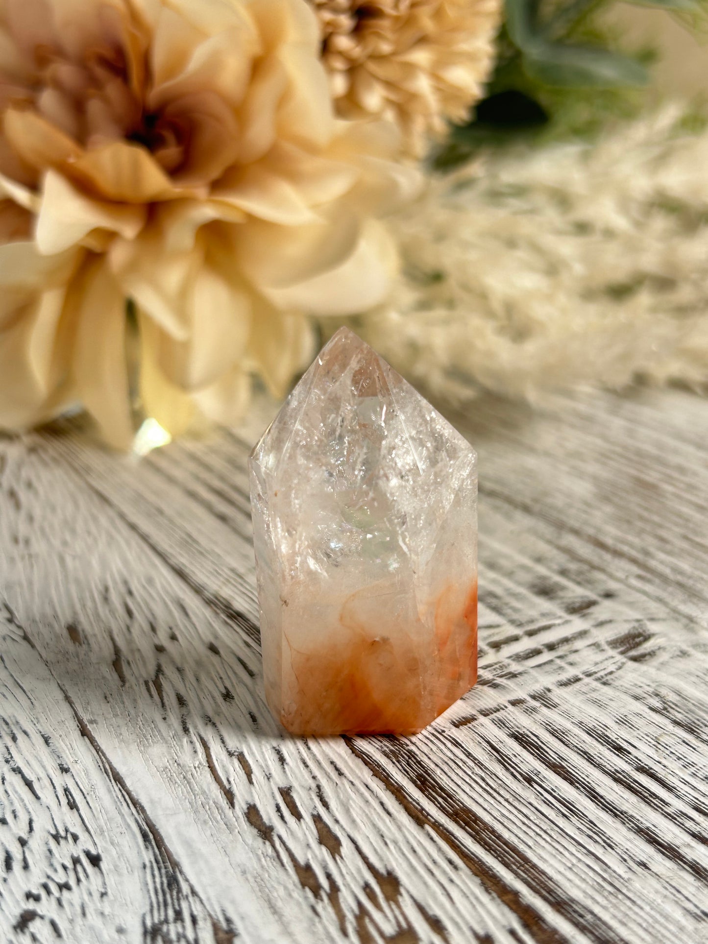 Crystal on a textured surface with flowers in the background