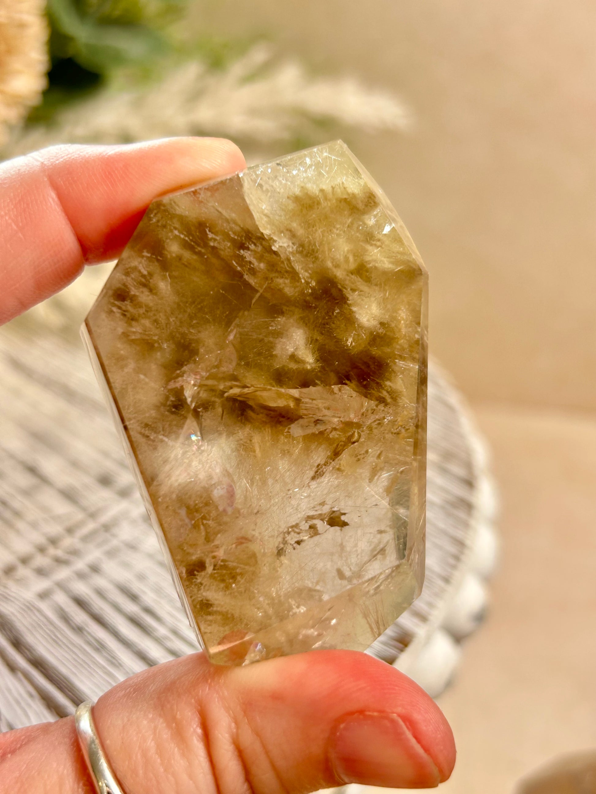 Person holding a smoky quartz crystal with a blurred background