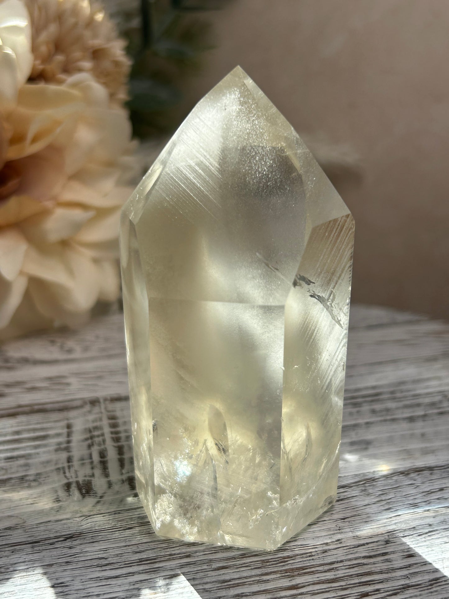 Clear crystal on a textured surface with flowers in the background