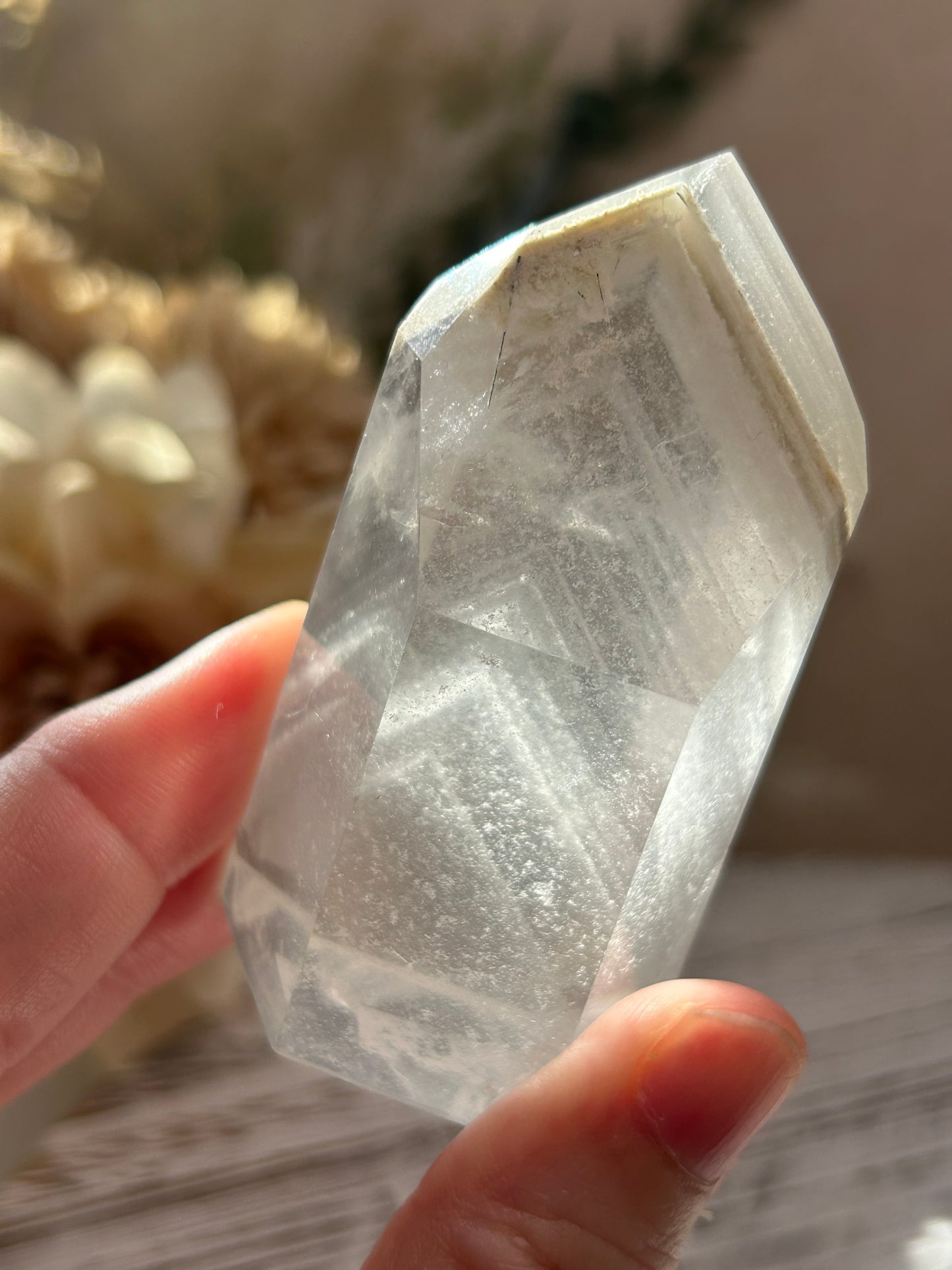 Person holding a clear crystal with a blurred background