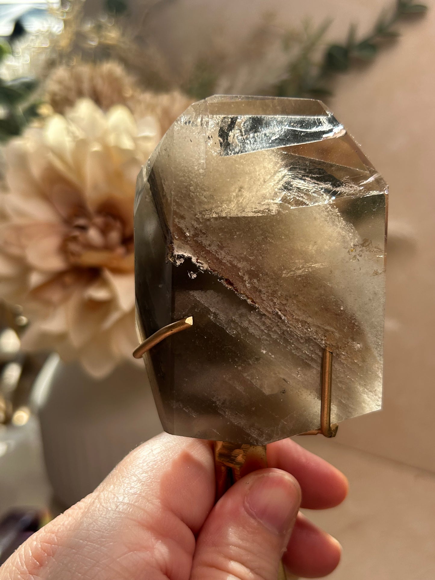 Phantom Quartz crystal specimen mounted on a custom display stand, showcasing visible phantom formations within the Quartz. Collector mineral specimen with unique internal crystal growth patterns.