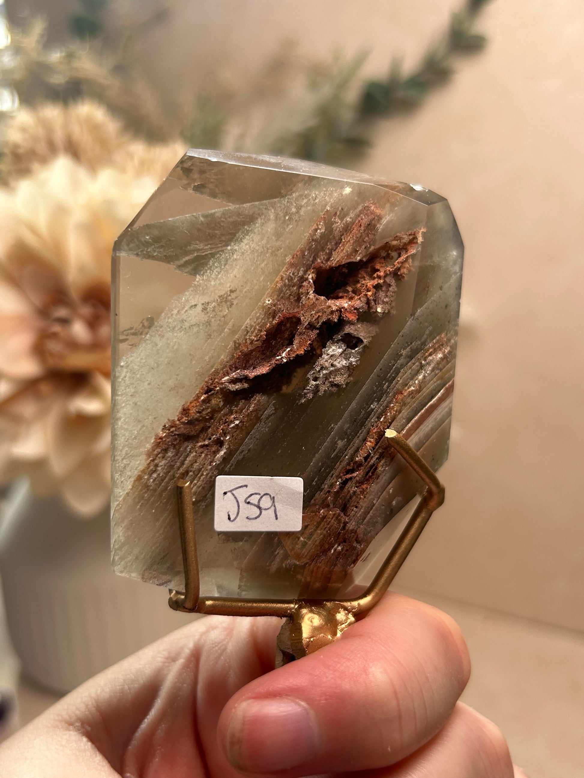 Phantom Quartz crystal specimen mounted on a custom display stand, showcasing visible phantom formations within the Quartz. Collector mineral specimen with unique internal crystal growth patterns.